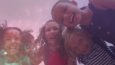 animación de partículas de luz sobre felices escolares diversas abrazando al aire libre