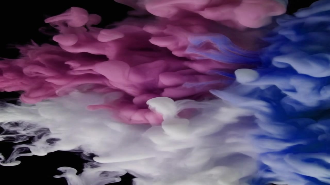 Nuvole di inchiostro rosa, blu e bianco che turbinano nell'acqua
