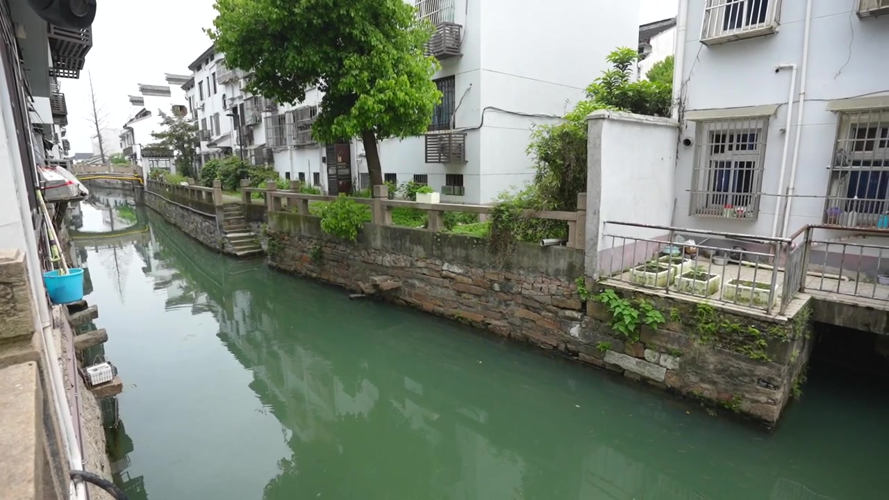 Doğu'nun Venedik'i Suzhou'daki bir kanalın sakin suyuna yansıyan geleneksel beyaz evler.