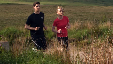 athletic couple jogging on a country trail