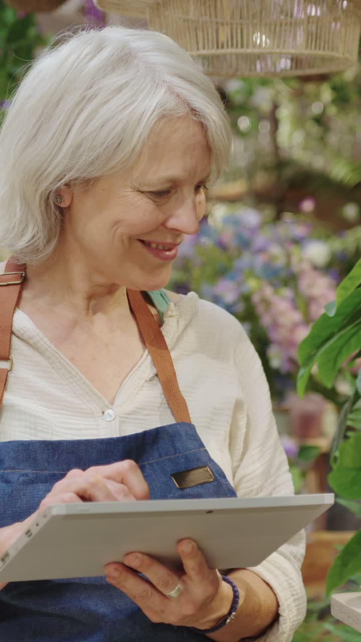 Woman using tablet in flower shop