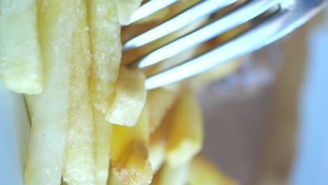 un tenedor lleno de papas fritas