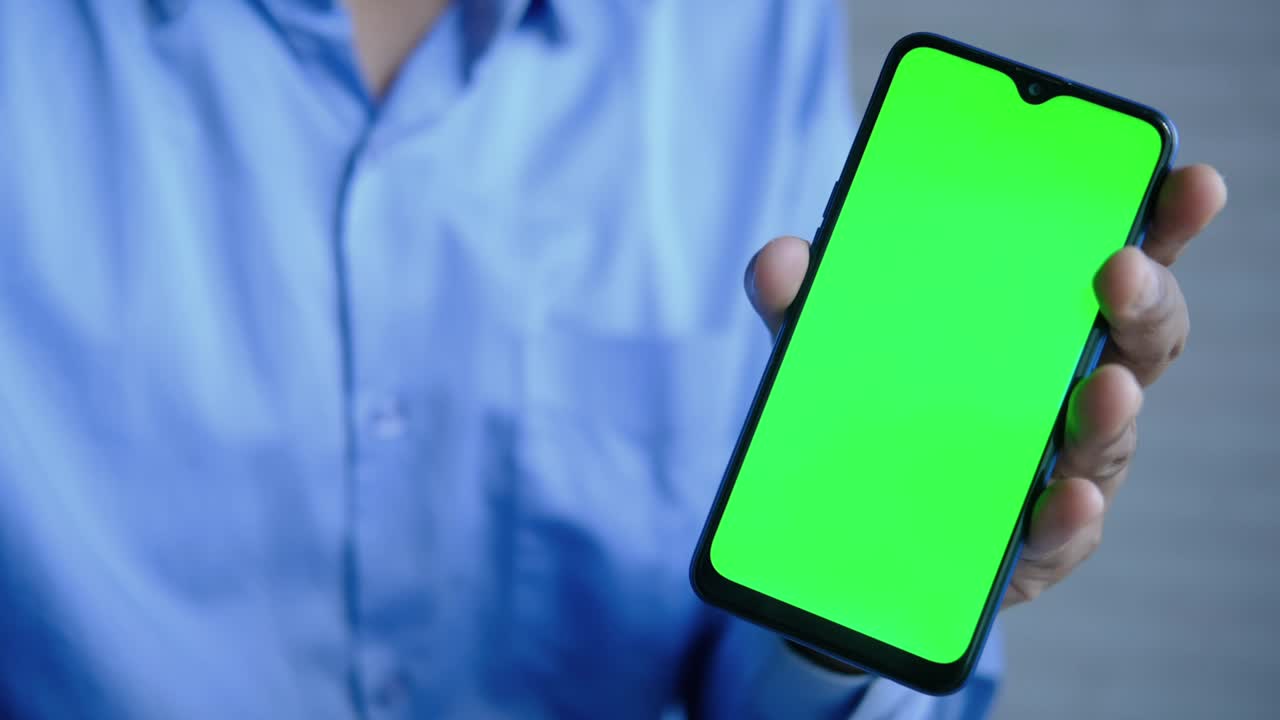 close up de la mano de un joven usando un teléfono inteligente con pantalla verde
