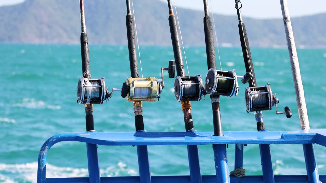 varas de pesca alineadas en una barandilla de barco