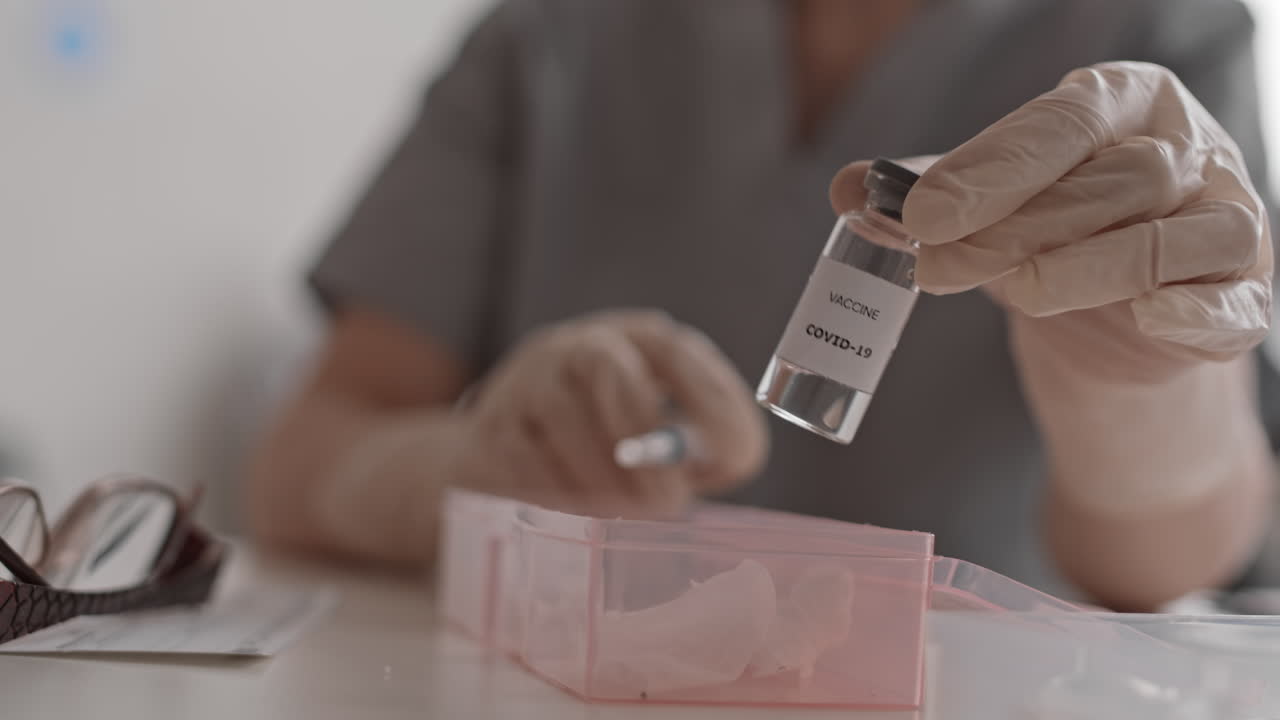 Shaking Ampoule with Vaccine in Hand