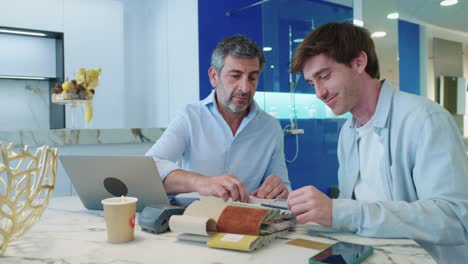 Two men discussing fabric samples
