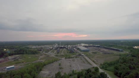 drone footage of an industrial area at dusk with a pink sunset