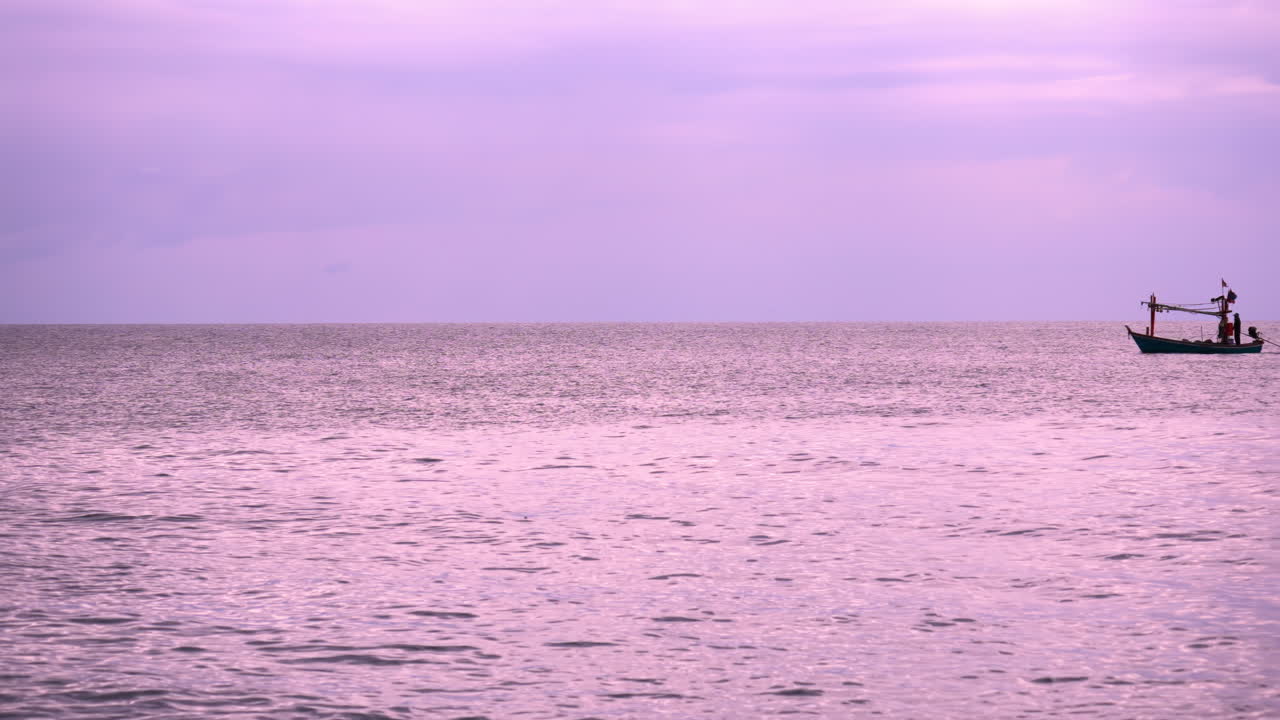 핑크색 해가 지는 바다와 태국 어부 보트 실루 ⁇ 이 구름이 많은 날을 가로지르고 있습니다.