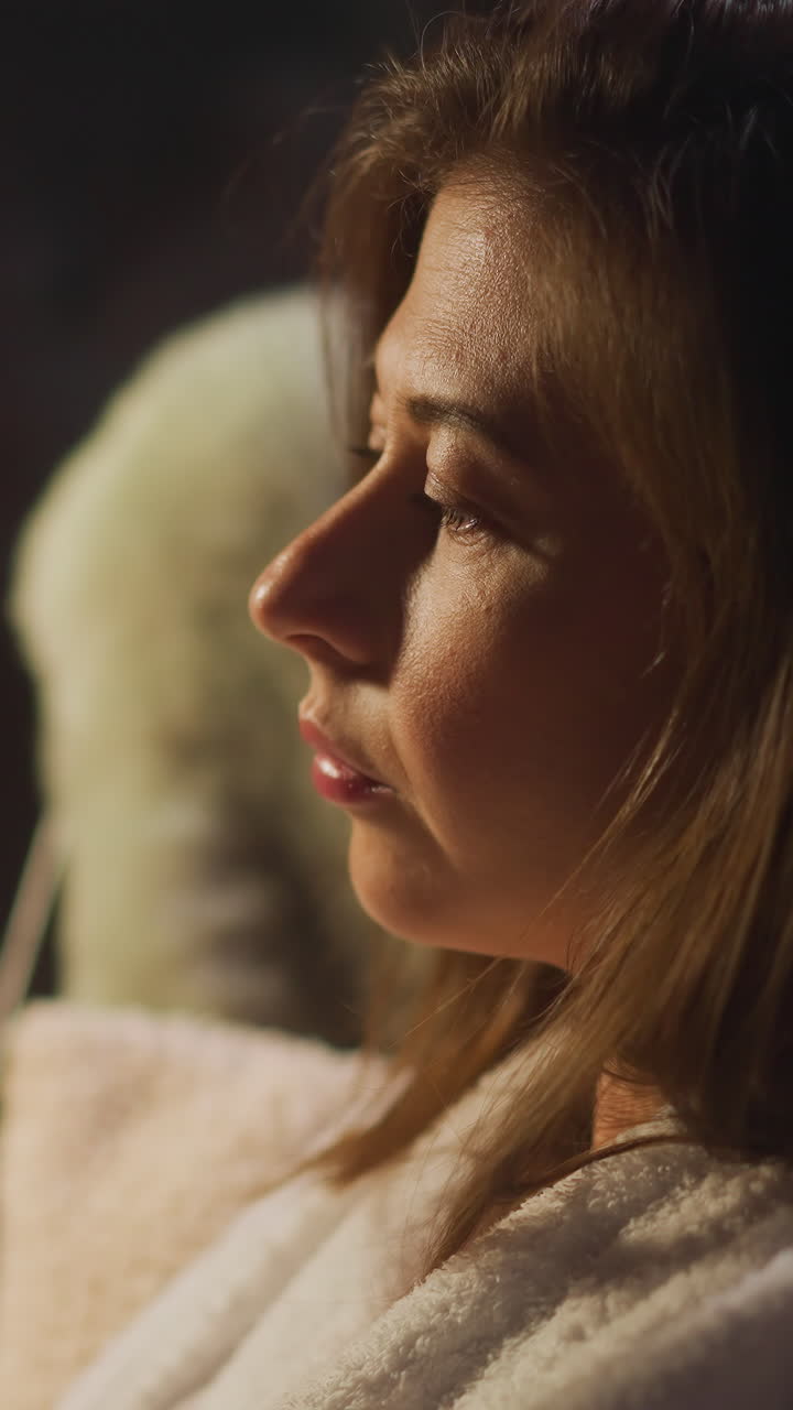Sad lady drinks alcohol to muffle moral pain sitting near window with reflection. Female dealing with mental problem that makes feel depressive and alone slow motion
