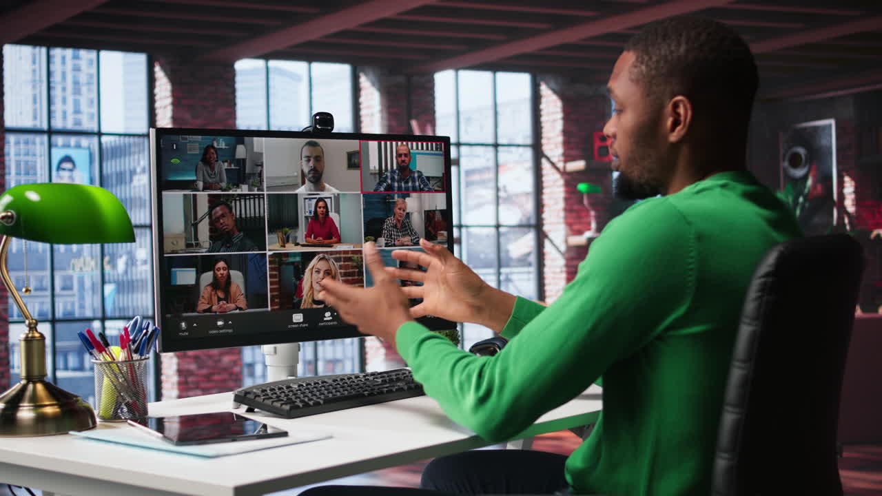 Vertical Video African american guy at desk is engaged in video call with coworkers