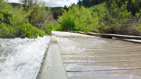 Rushing-river-water-is-seen-over-flowing-on-top-of-a-bridge