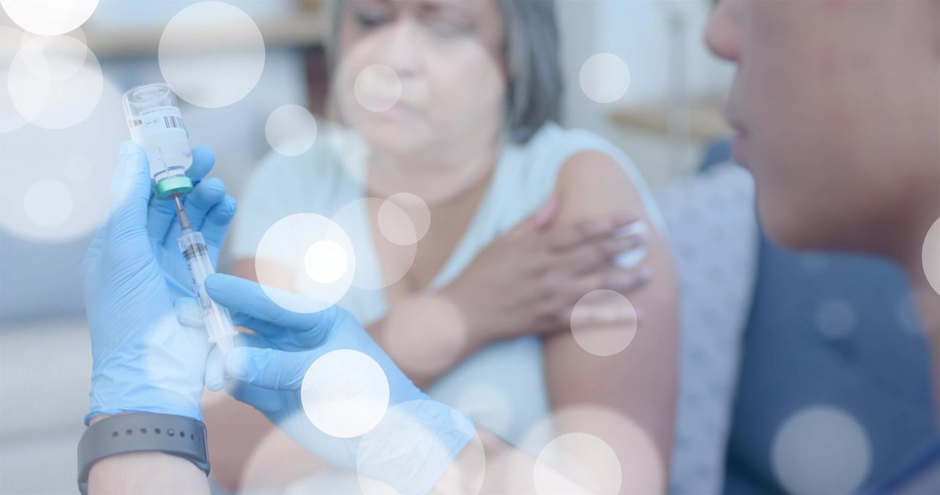 Medizinisches Fachpersonal entfernt den Fläschchenverschluss, zieht Impfstoff auf, klopft auf den Spritzenzylinder und injiziert einem Patienten zu Hause.