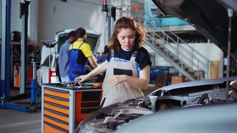 mechanic tightens car screws with wrench