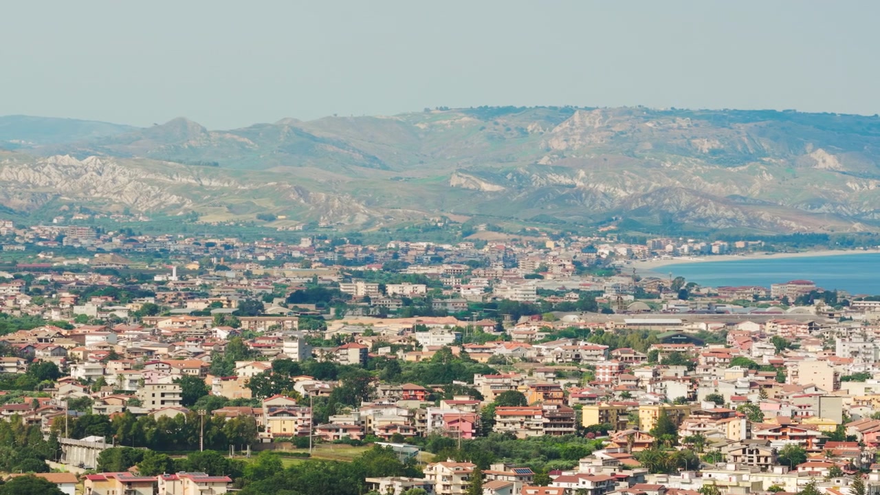 Vista panoramica di una città costiera con montagne e mare