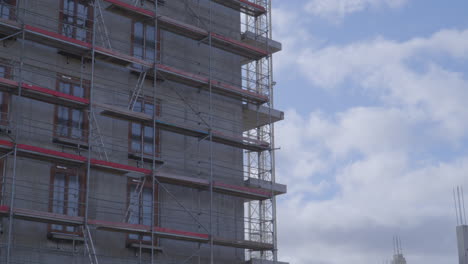 andamios instalados junto a un edificio en construcción - construcción moderna - zoom out