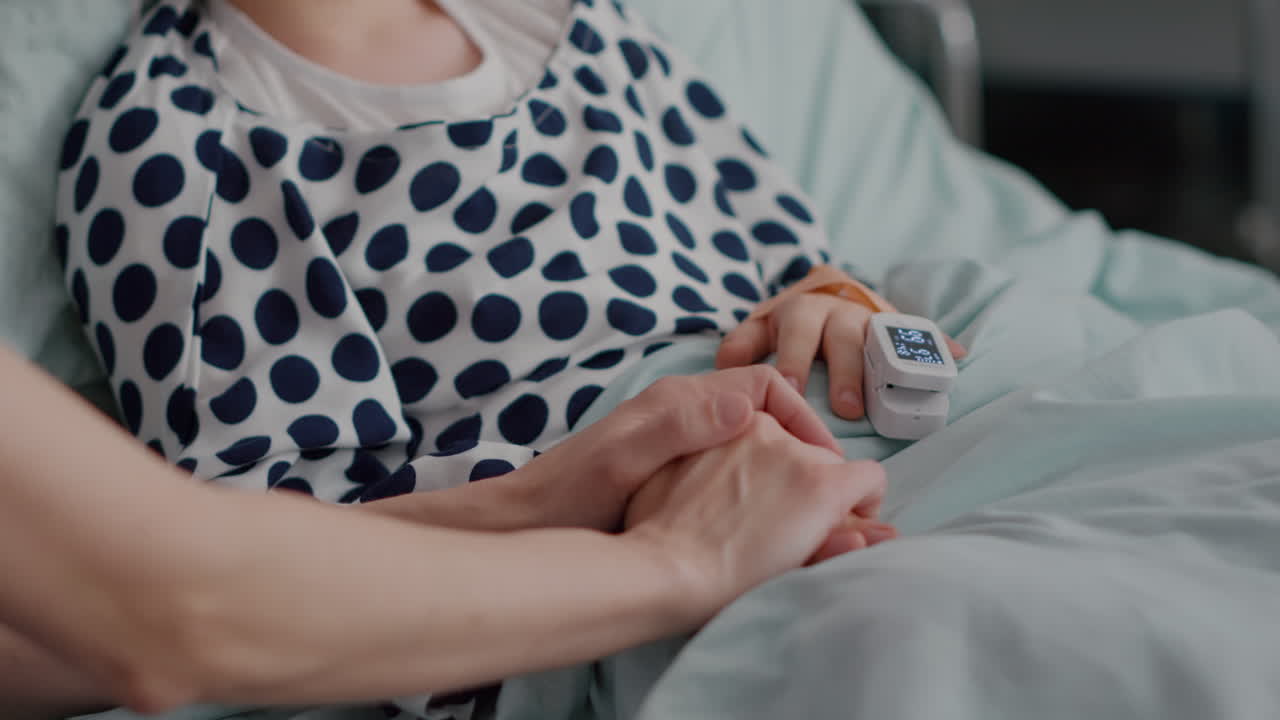 Mother holding daughter hands waiting for medication treatment after sickness infection