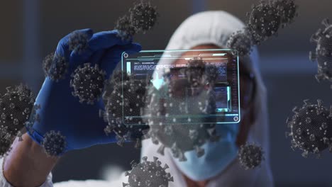 Animation-of-covid-19-cells-over-scientist-in-ppe-suit-holding-screen-with-medical-data-processing