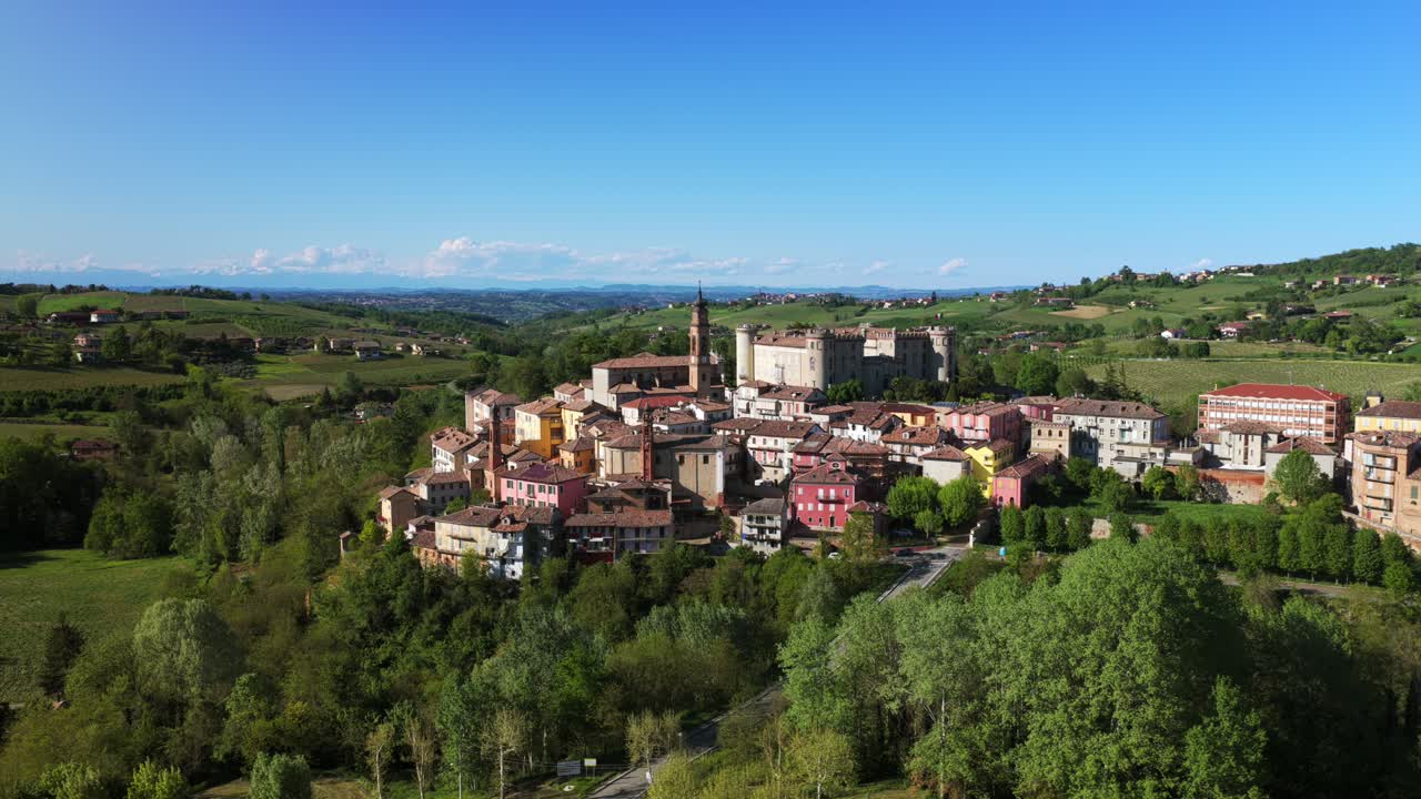 Costigliole d'Asti, historic hilltop village with castle, surrounded by lush green landscape, Piedmont. Italian travel. Italy. Aerial lateral view