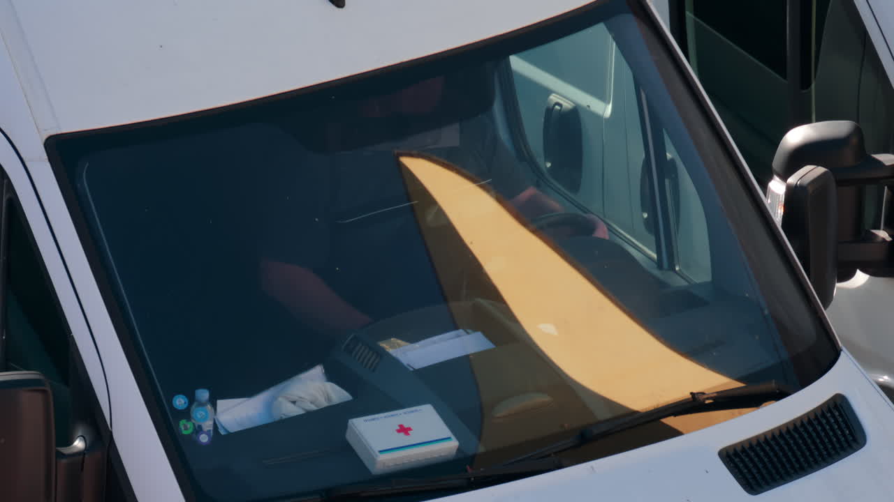 Chisinau, Moldova - September 28, 2025: A man siting behind the wheel of a white van, viewed through the windshield