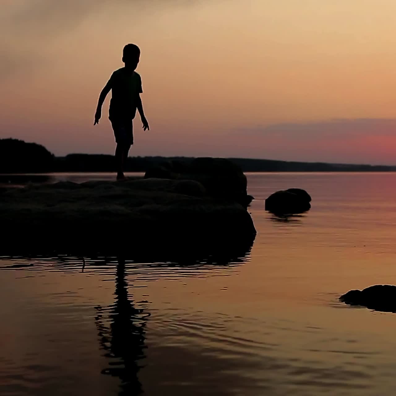 Boy Playing On Stony Beach