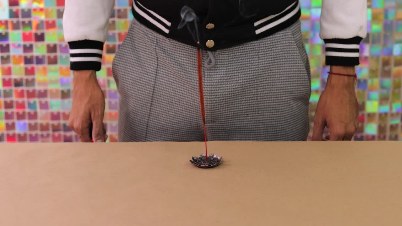 Man lighting incense stick on a table
