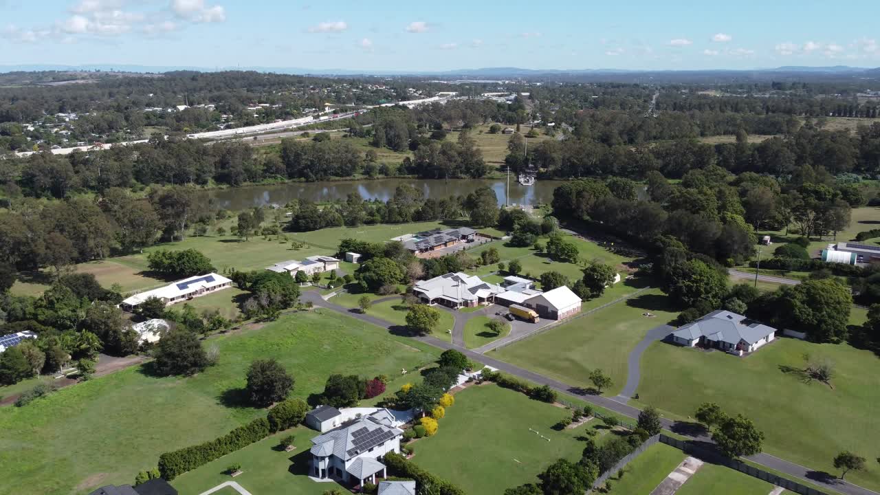 4K Aerial View of large rural homes approaching a river with a ferry in Australia