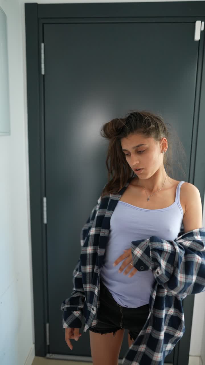 joven posando con una camisa a cuadros y una camiseta