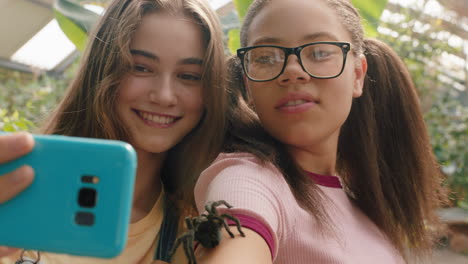 teenage girls playing with tarantula spider friends taking photos using smartphone sharing zoo excursion on social media having fun learning about arachnids at wildlife sanctuary 4k