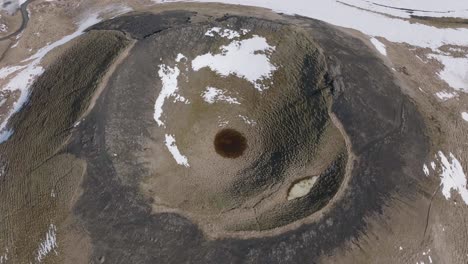 aerial view of volcano crater by frozen lake in landscape of iceland on sunny late winter day