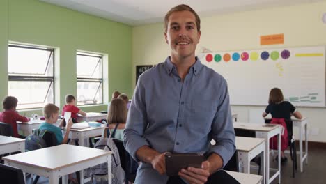 maestro masculino que usa una tableta digital en la clase