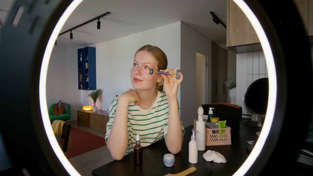 제이드 롤러 로 얼굴 마사지를 시연 하는 여자