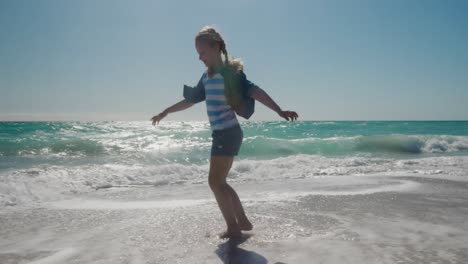 chica joven caminando en el agua en la playa