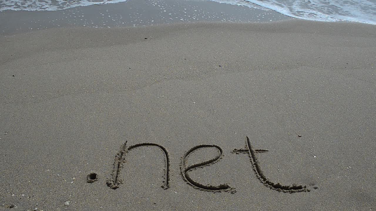 The word .net handwritten in sand on a beach. Shooting on the beach