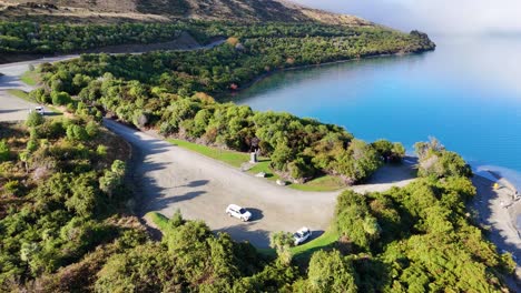 drone footage captures a tranquil lake surrounded by vibrant autumn foliage and clear skies, showcasing natural beauty and serenity