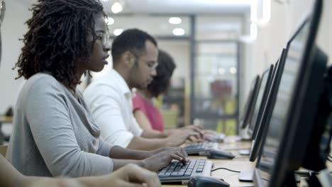 businesspeople sitting at tables and working with computers