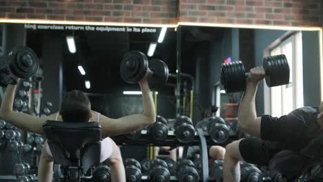 people exercising with dumbbells in a gym