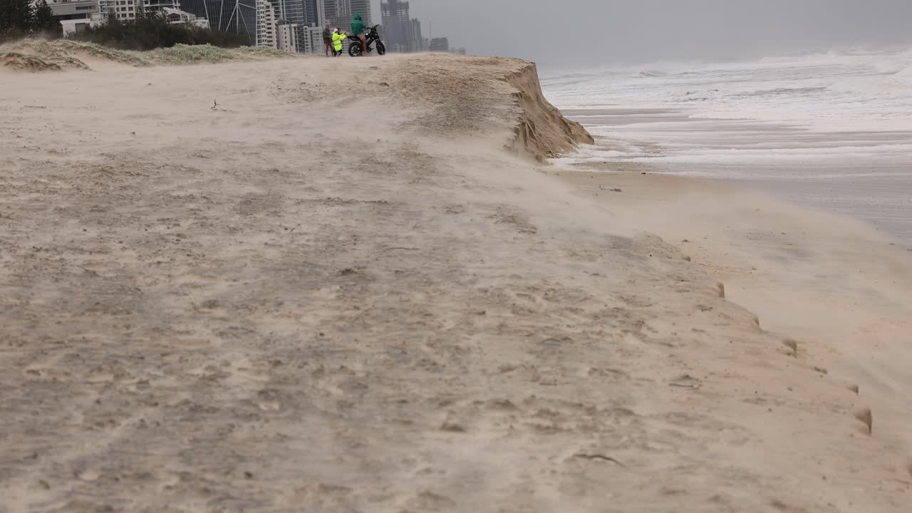 브로드비치 (broadbeach) 의 해안 침식을 보여주는 일련의 프레임, 모래 해안선에 대한 바다 파동의 영향을 강조합니다.