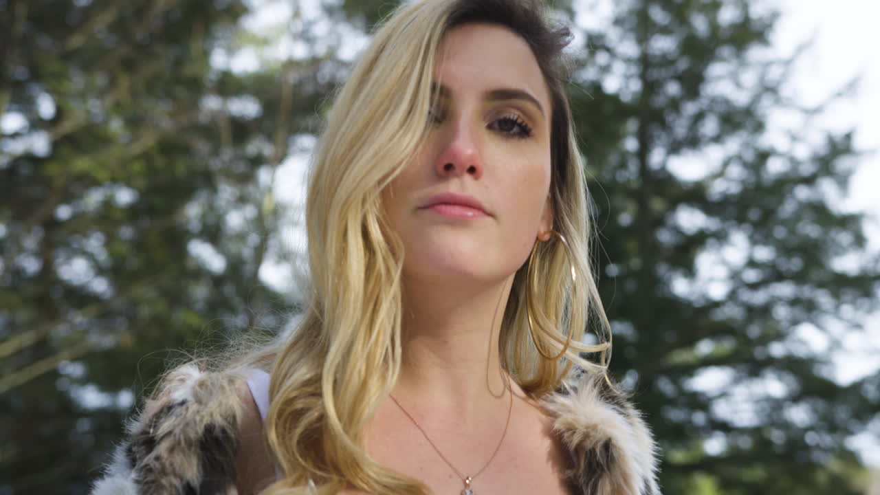 Stylish confident young woman smiles and poses for the camera, turns and walks away