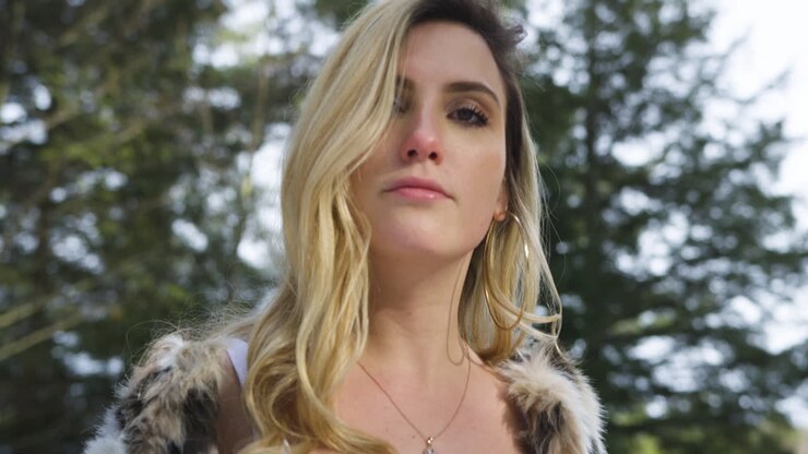 élégante jeune femme confiante sourit et pose pour la caméra, se tourne et s'éloigne