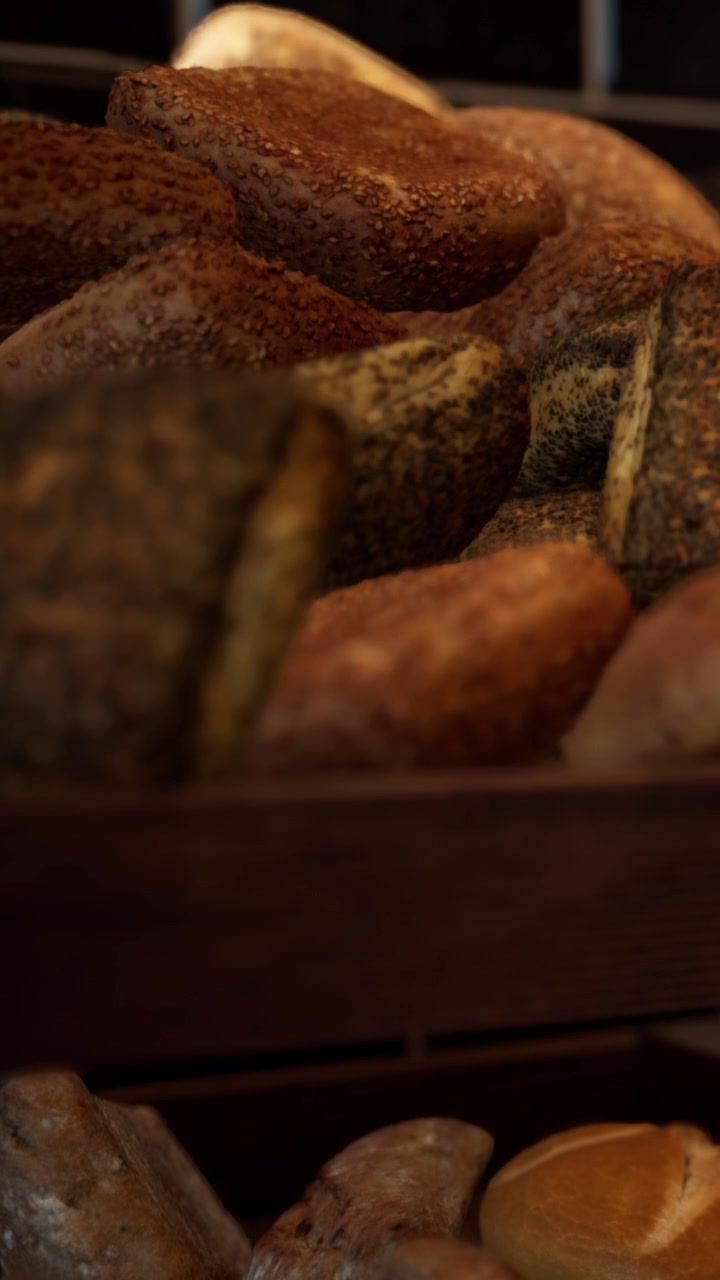 Fresh bread rolls and loaves stacked on wooden shelf in bakery
