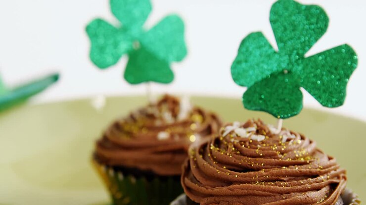 Chocolate muffin with chocolate cream topping and shamrock stick for st patricks