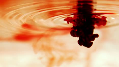 orange ink swirling in water