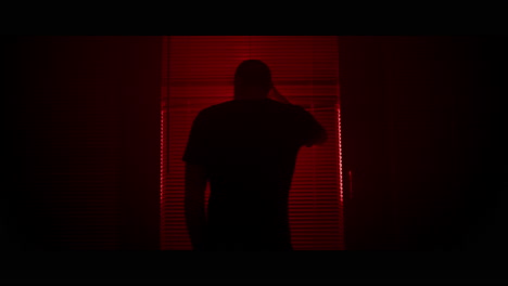man looking through a window at night