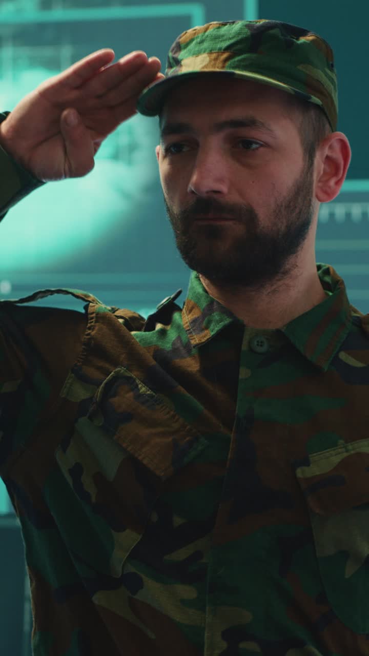 Soldato barbuto in uniforme mimetica che saluta nella sala di controllo