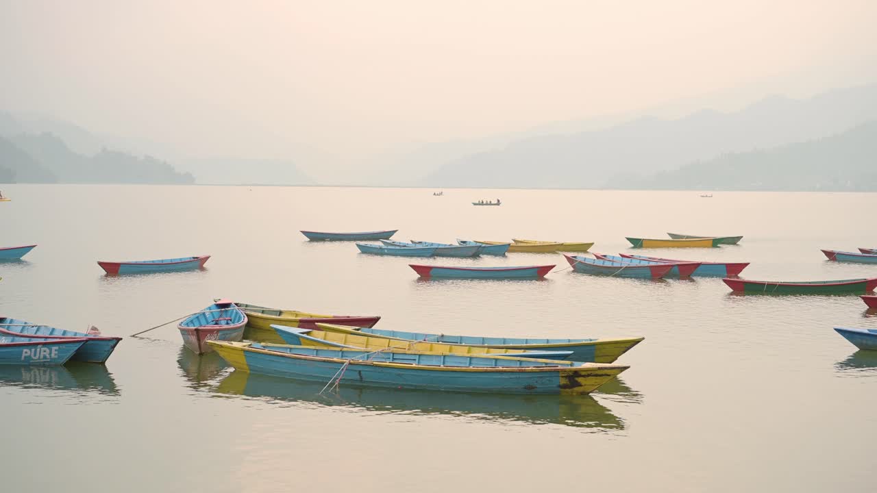 colorido viaje turístico en barco remando barcos en el lago fewa en pokhara al atardecer en nepal, hermoso lago fewa con increíbles paisajes dramáticos de montaña en pokhara