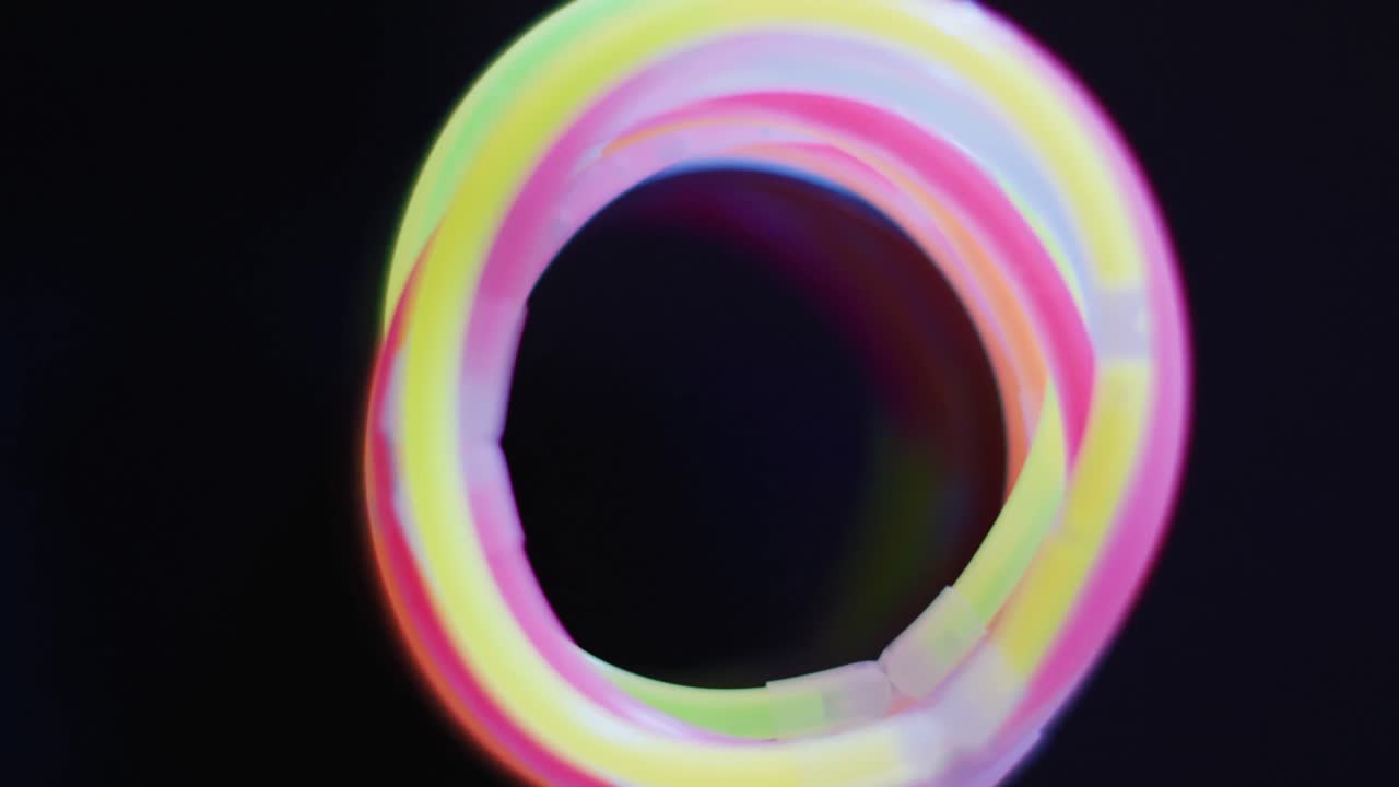 animación de múltiples palos de brillo de neón coloridos sobre fondo negro con espacio de copia