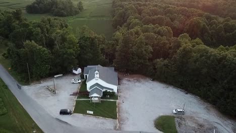 Amazing video of a small church. the camera pans up revealing the tree line and a nice sunset. great for final shots of an edit