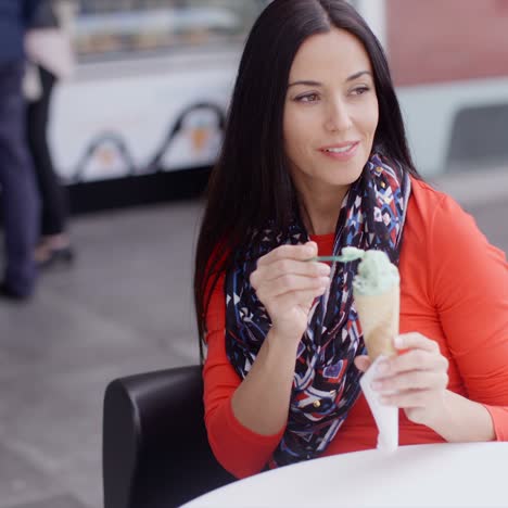 mujer comiendo un helado en un salón o cafetería