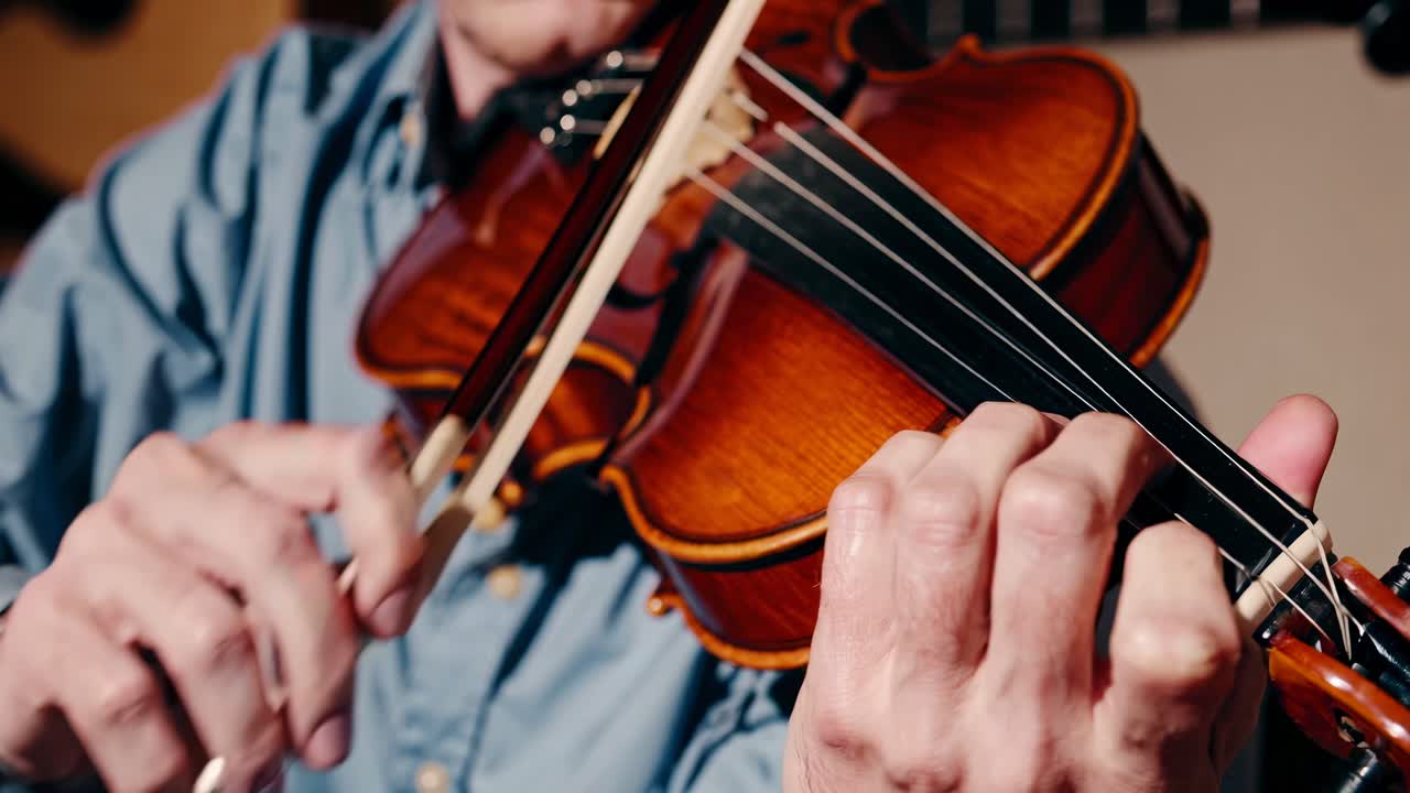 Close-up video of hands playing a violin, showcasing intricate finger movements