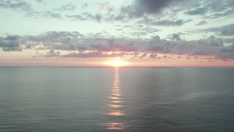 sunset over calm, crystal clear oceans as waves roll in